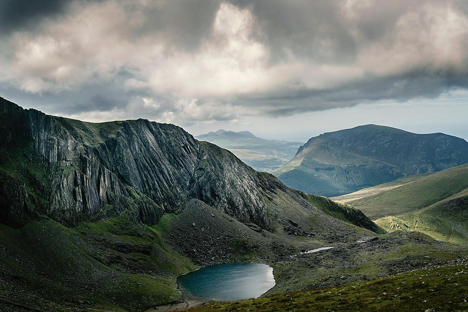 A dramatic mountain valley beneath changing clouds
