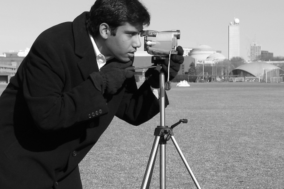 A photographer using a camera on a tripod outdoors